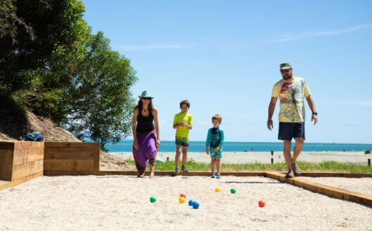 Family playing Petanque by the sea