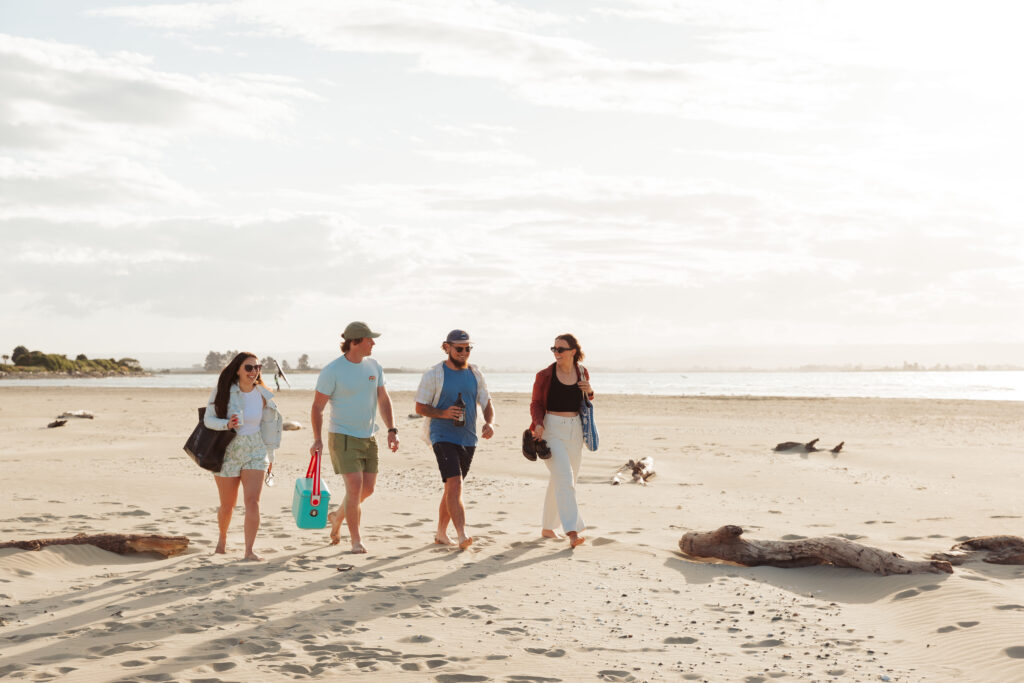 Group walking on Tāhunanui beach