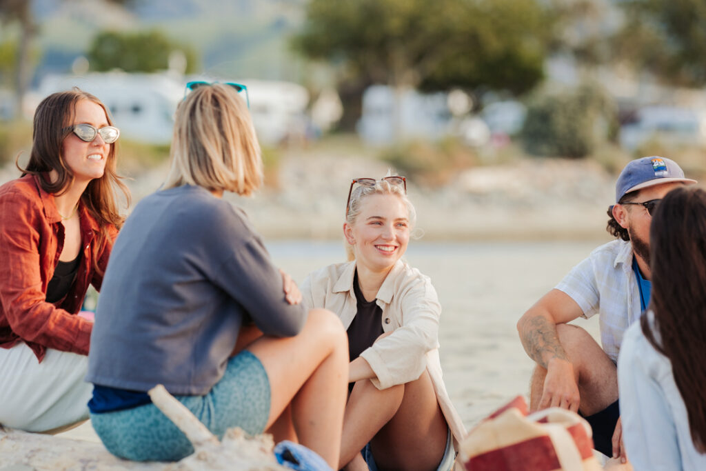 Group of people sitting on Tāhuna Beach Holiday Park